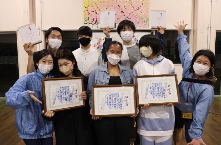 「第10回 高校生ビジネスプラングランプリ」でベスト100に選出された綾井さん・野澤さん・松村さんに八洲学園大学国際から「功労賞」が贈られる。スクーリング中に記念撮影